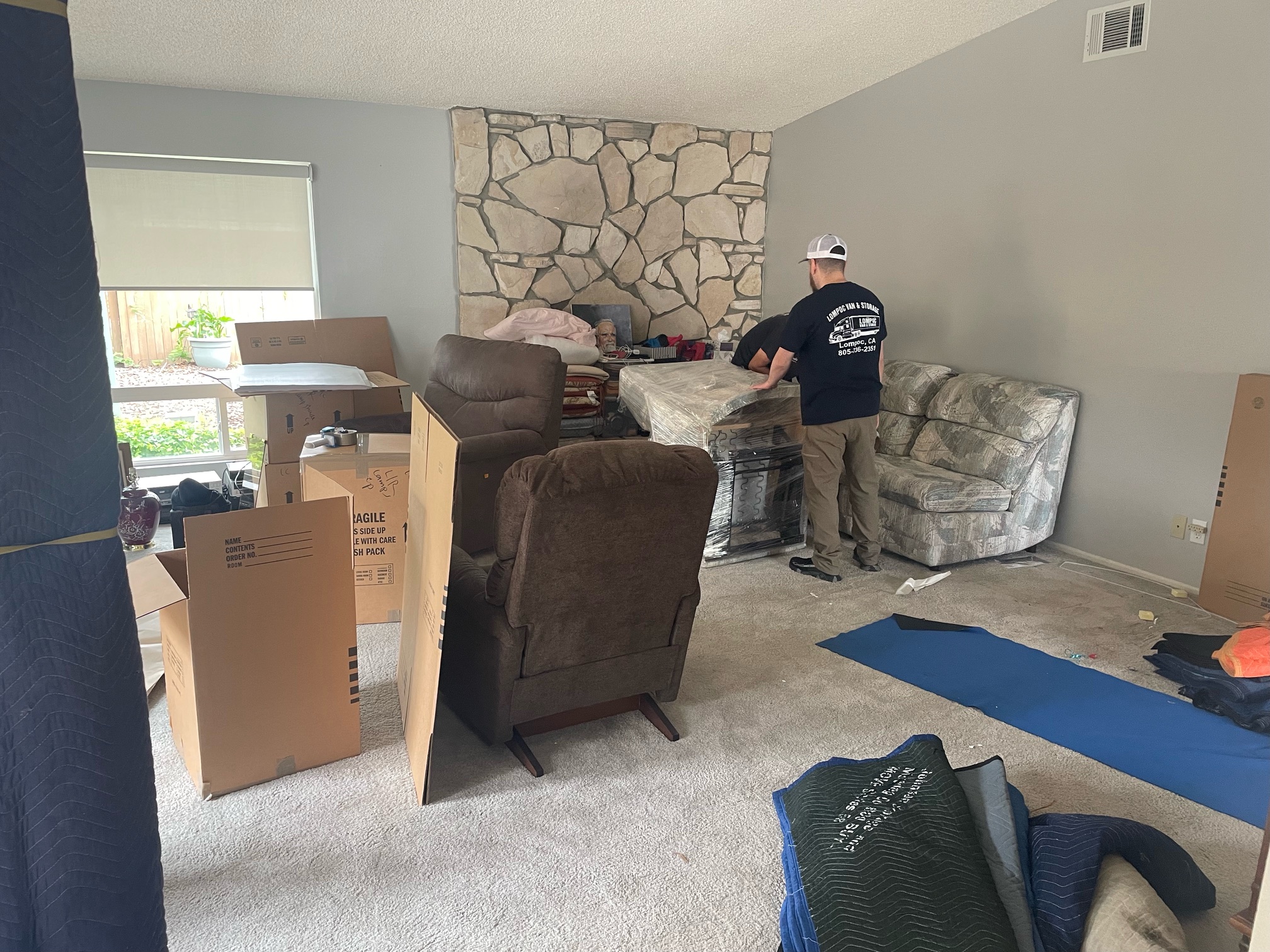 two movers wrapping furniture