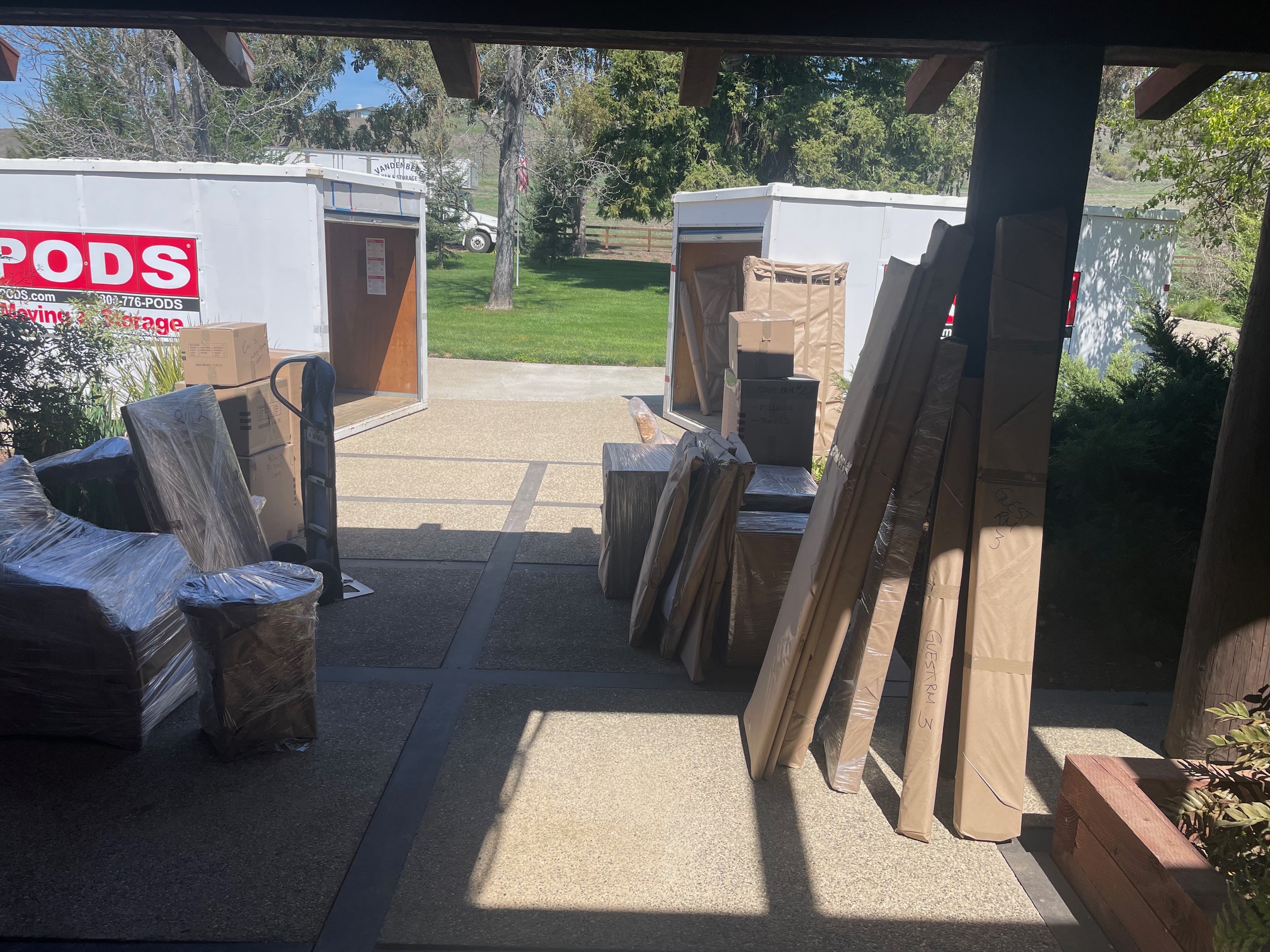 stacked boxes outside of home next to storage pods